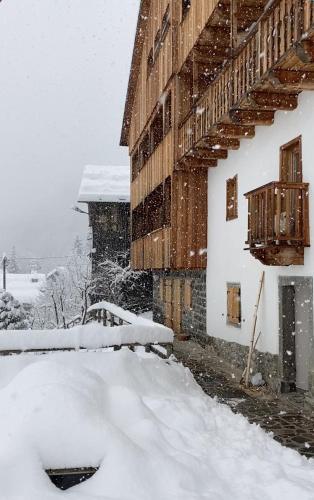 a snow covered building with a pile of snow next to it at Studio Ebi Vacation - Alleghe - Monte Civetta in Alleghe