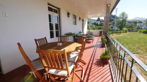 a wooden table and chairs on a balcony at Quinta do Arieiro in Arouca
