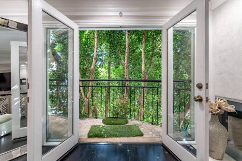una stanza con porte che si aprono su un giardino alberato di Barham Boutique Townhouse a Los Angeles