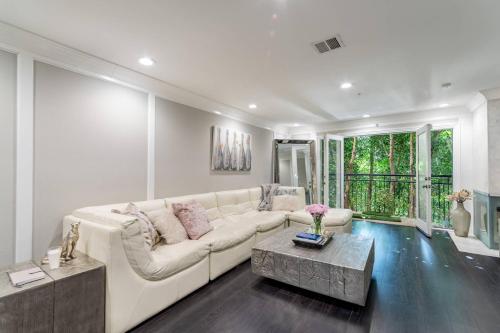 un soggiorno con un divano bianco e un tavolo di Barham Boutique Townhouse a Los Angeles