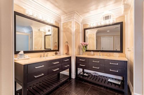 a bathroom with two sinks and two mirrors at Barham Boutique Townhouse in Los Angeles