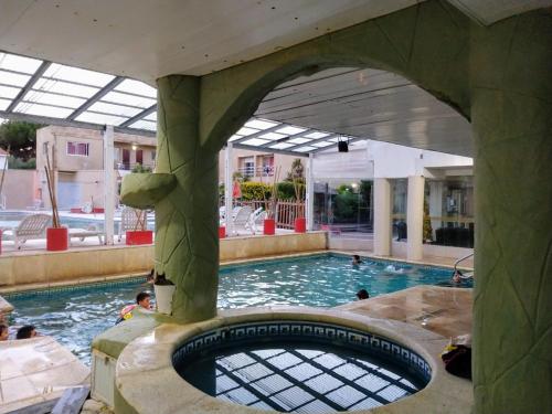 a swimming pool with people in the water at San Remo Resort Hotel in Santa Teresita