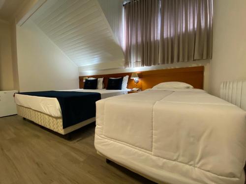 a bedroom with two beds in a room at Lapônia Hotel Gramado in Gramado