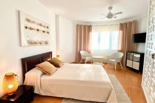 a bedroom with a bed and a table and chairs at Casa de Mont-roig delante de la playa in Montroig