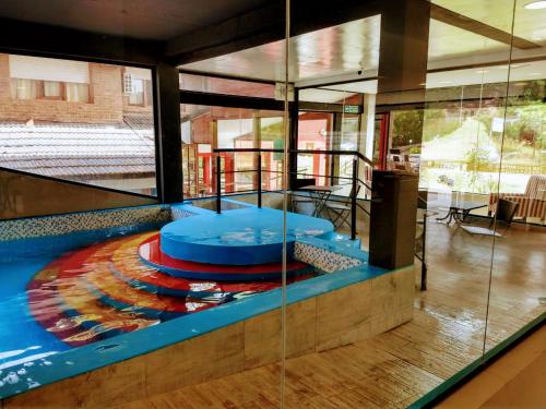 a swimming pool in a building with a glass wall at San Remo Viking Hotel in Pinamar