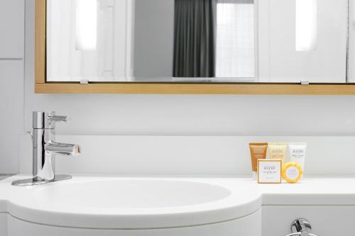 a bathroom with a white sink and a mirror at Club Quarters Hotel Rittenhouse Square, Philadelphia in Philadelphia