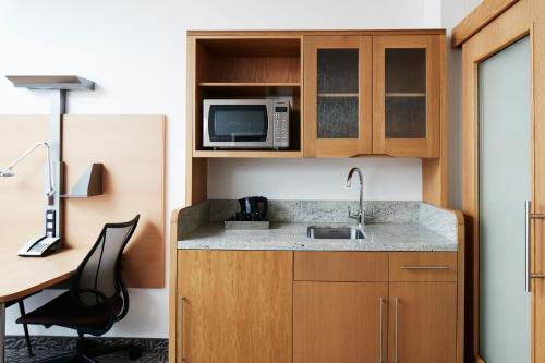 a small kitchen with a sink and a microwave at Club Quarters Hotel Covent Garden Holborn, London in London