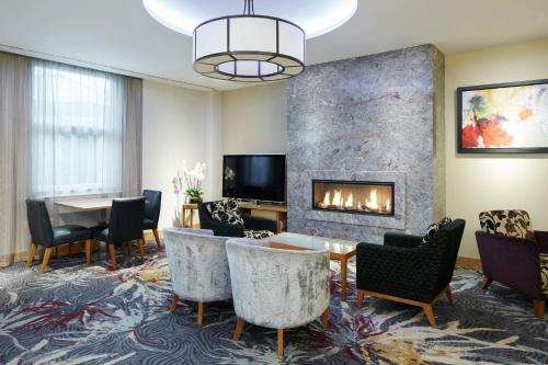 a living room with a fireplace and a table and chairs at Club Quarters Hotel Covent Garden Holborn, London in London