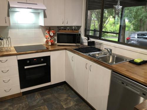 a kitchen with a sink and a microwave at Bowral Bungalow in Bowral