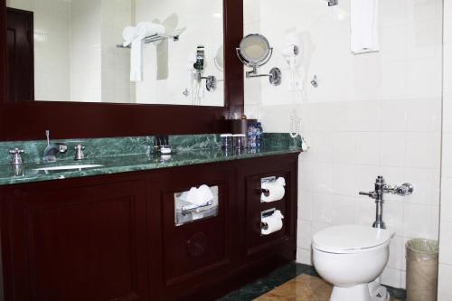 a bathroom with a toilet and a sink and a mirror at Hotel Las Americas in Guatemala
