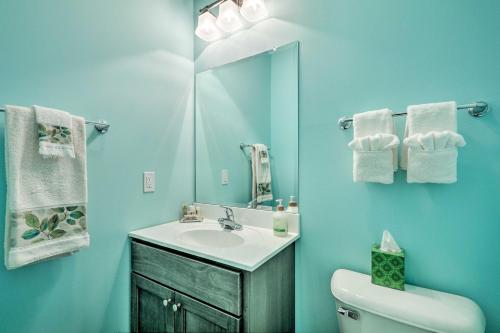 uma casa de banho com um lavatório, um WC e um espelho. em Serene Poconos Cabin with Fire Pit and Creek Access! em Brodheadsville