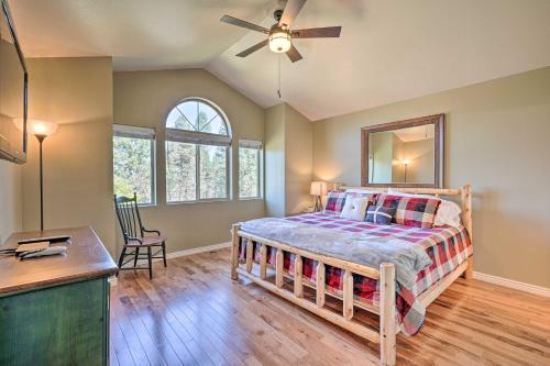 a bedroom with a bed with a ceiling fan and a desk at Hilltop Haven in Florissant Deck and Mountain View! in Florissant