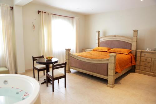 a bedroom with a bed and a table and a tub at Lunahuana River Resort in Lunahuaná