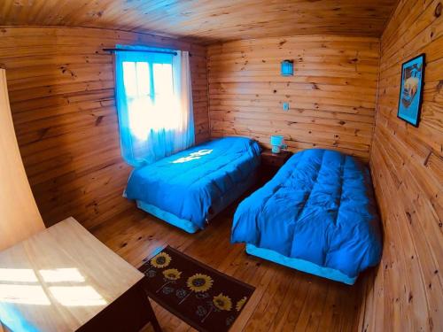 a room with two beds in a log cabin at CABAÑAS AIRES DE MAROMILLAS in Constitución