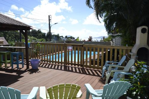 een terras met stoelen en een tafel en een hek bij an eol caraibes in Trois-Rivières
