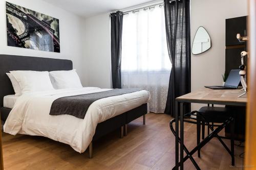 1 dormitorio con 1 cama y escritorio con ordenador portátil en La Clé des Clos, en Beynes