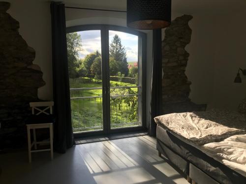 a bedroom with a large glass door with a view at Gästehaus Lausnitz Zimmer in Lausnitz