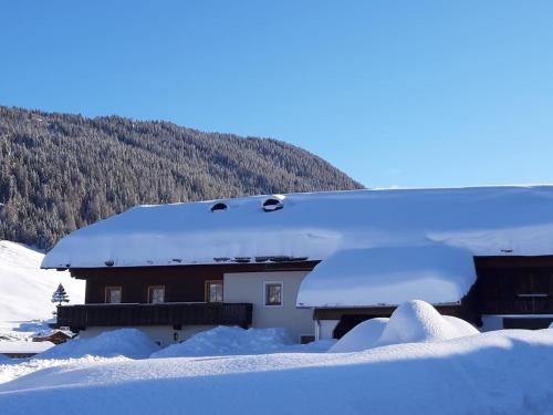 a house covered in snow with a roof at Ferienhaus Köck in Kartitsch