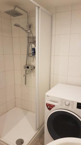 a washing machine in a bathroom with a shower at Lilli Ferienwohnung in Handewitt