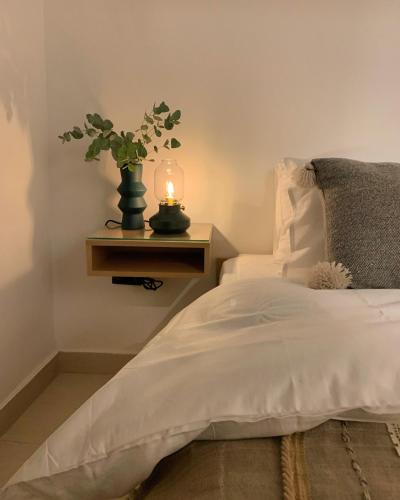 a bedroom with a bed with a candle on a table at Nu Fifty Two in Amman