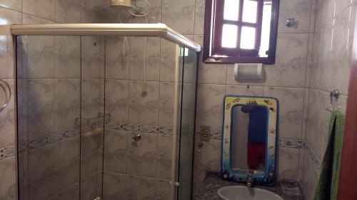 a bathroom with a shower and a sink and a mirror at CASA COM 4 QUARTO EM BUZIOS - 2 SUITES - Perto de Tudo in Búzios