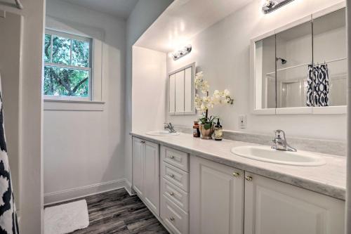 een witte badkamer met 2 wastafels en een raam bij Quiet Jacksonville Retreat - 4 Miles to Downtown! in Jacksonville