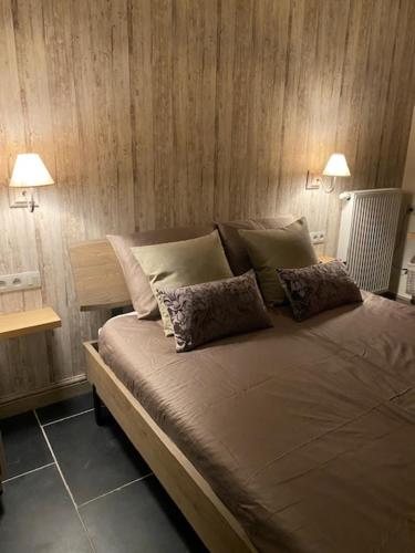 a bedroom with a large bed with two lamps at B&B 't Hoveke in Wingene