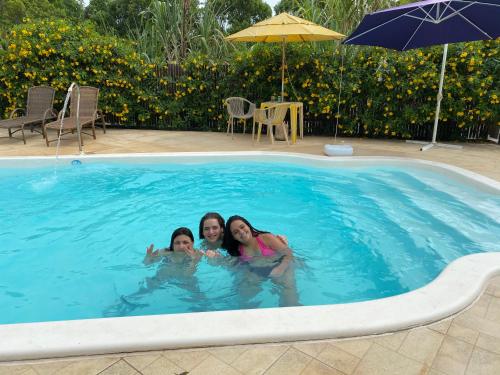 three women are swimming in a swimming pool at Pousada Toca do Ceará in Regencia Augusta