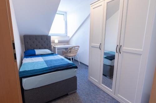 a small bedroom with a bed and a desk at Ferienwohnung Burghausen in Unterneukirchen