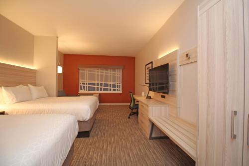a hotel room with two beds and a flat screen tv at Holiday Inn Express & Suites Ocala by IHG in Ocala