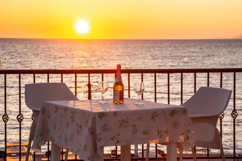 a bottle of wine sitting on a table on the beach at Apartments Oliva in Utjeha