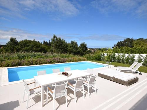 eine Terrasse mit einem Tisch und Stühlen sowie einem Pool in der Unterkunft Comfortable villa with private pool in Nadadouro in Nadadouro