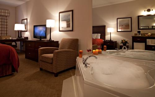 a hotel room with a tub and a living room at Country Inn & Suites by Radisson, Calgary-Northeast in Calgary