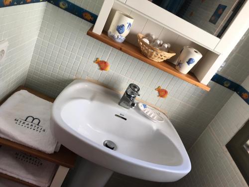 ein Badezimmer mit einem weißen Waschbecken und einem Spiegel in der Unterkunft Casa Esperanza in Benitatxell
