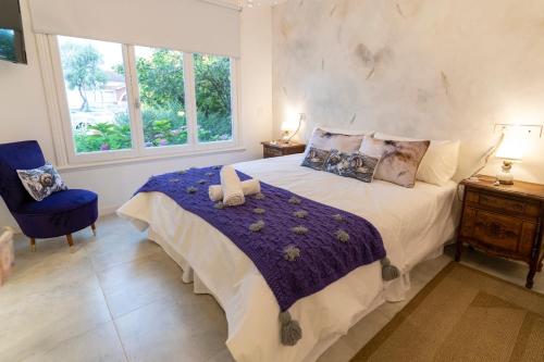 a bedroom with a large bed and a blue chair at Allegra Dalila Casa Hotel-Arte in Tandil