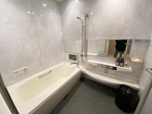 a white bathroom with a tub and a sink at リバーサイド in Imabari