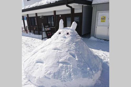 a snowman made out of snow in front of a house at BBQ可 1日1組限定 貸切別荘 秘密基地 は恐竜博物館まで3km スキージャム勝山まで12km in Katsuyama