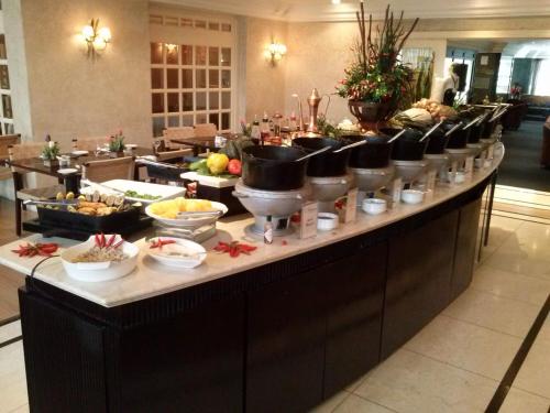 a buffet line with bowls and dishes of food at Mabu Curitiba Business in Curitiba