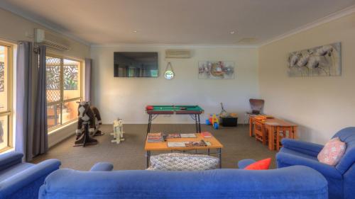 a living room filled with furniture and a tv at Country Roads Motor Inn in Goondiwindi