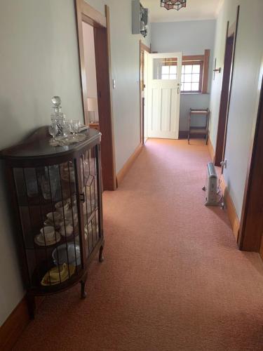 a hallway with a room with a table with wine glasses at One Panama in Martinborough 
