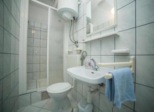 biała łazienka z toaletą i umywalką w obiekcie Apartments Desa - sea view w Bol
