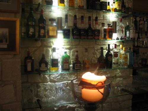a bar with a candle on a counter with bottles at Hill View Hotel Apartments in Pissouri