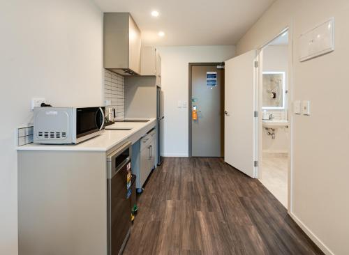 a kitchen with a microwave on top of a counter at La Quinta by Wyndham Remarkables Park Queenstown in Queenstown