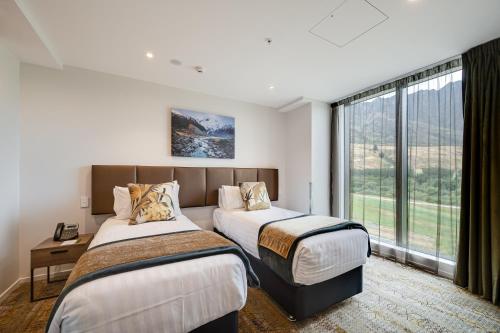 a hotel room with two beds and a window at La Quinta by Wyndham Remarkables Park Queenstown in Queenstown