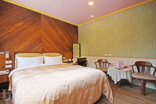 a bedroom with a bed and a table and chairs at Sun Moon Lake Tan Hsiang Yu B&B in Yuchi