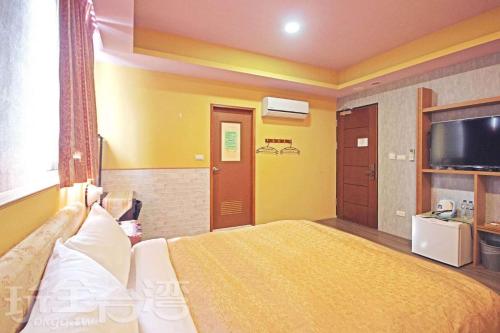 a hotel room with a bed and a television at Sun Moon Lake Tan Hsiang Yu B&B in Yuchi