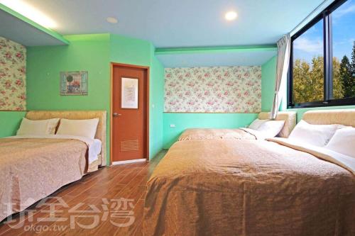 two beds in a room with green walls at Sun Moon Lake Tan Hsiang Yu B&B in Yuchi