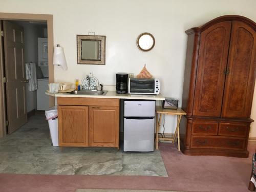 a kitchen with a white refrigerator and a microwave at Oak Valley Inn and Suites in Geneseo