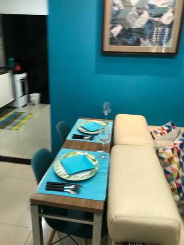 a table with a bench next to a blue wall at #01 Boulevard Amazon Suites in Manaus