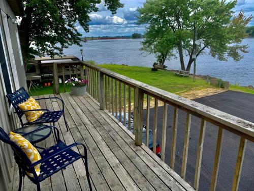two chairs on a porch with a view of the water at Mississippi River Cabin in Bellevue
